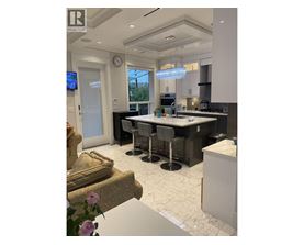 A modern kitchen with a large island and a dining area.