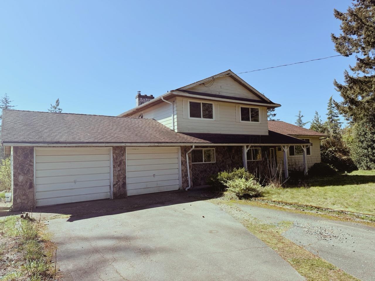 A house with a garage and a driveway in front.