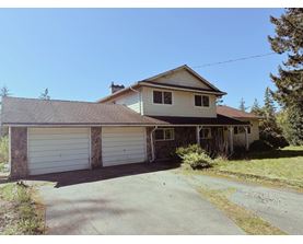 A house with a garage and a driveway in front.