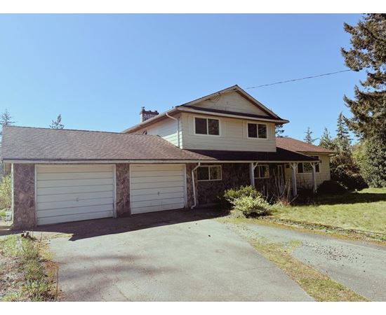 A house with a garage and a driveway in front.