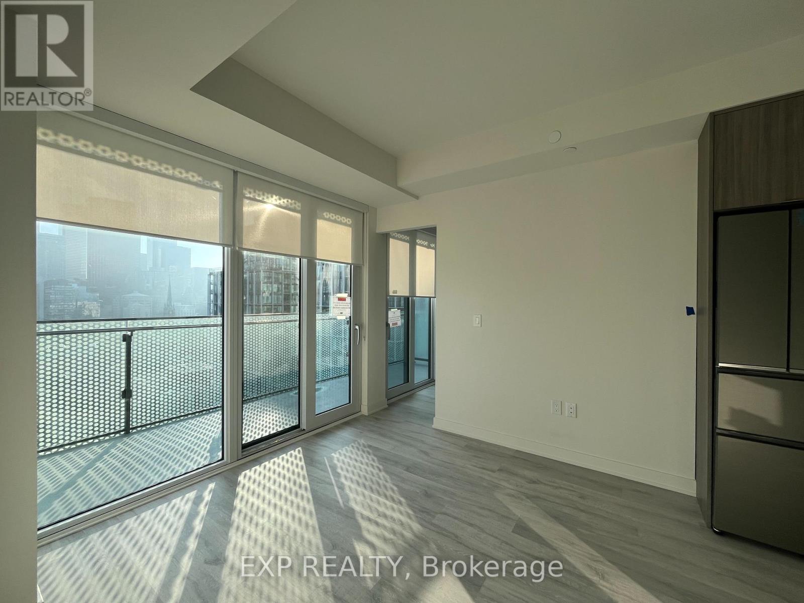 A spacious room with a large window and a sliding glass door.