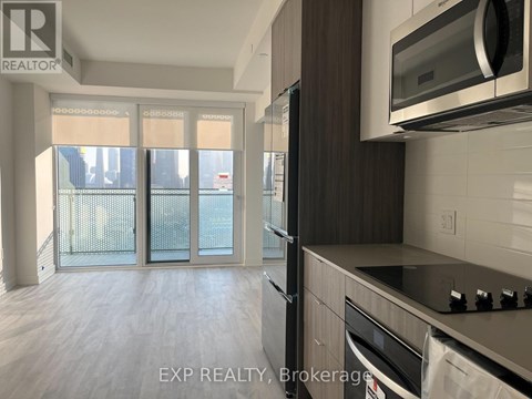 A kitchen with a microwave and oven built into the cabinetry.