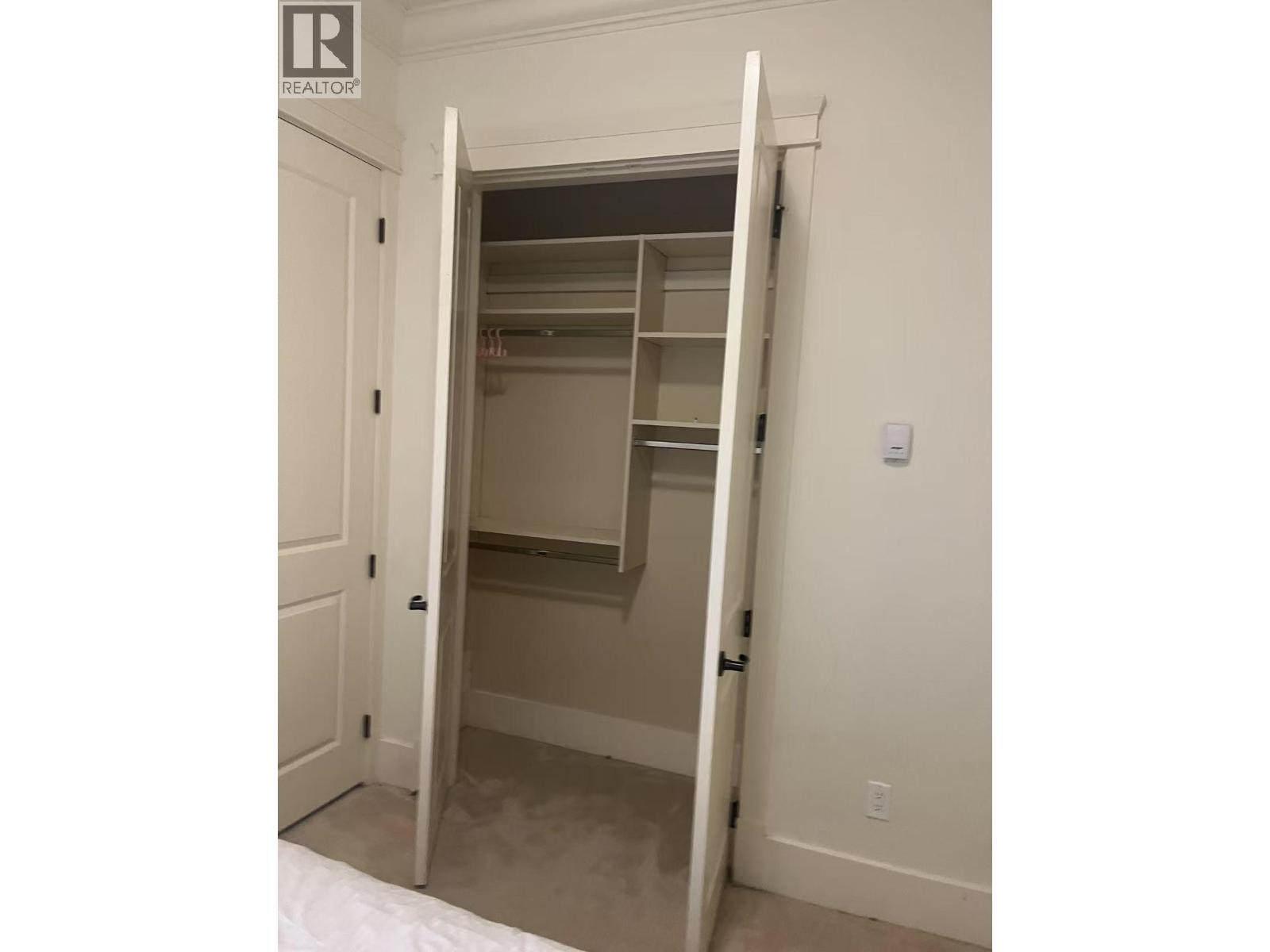 A white door is open to a small closet.