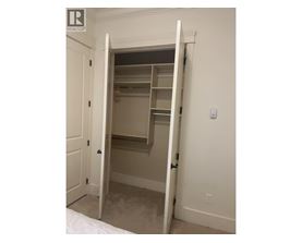 A white door is open to a small closet.