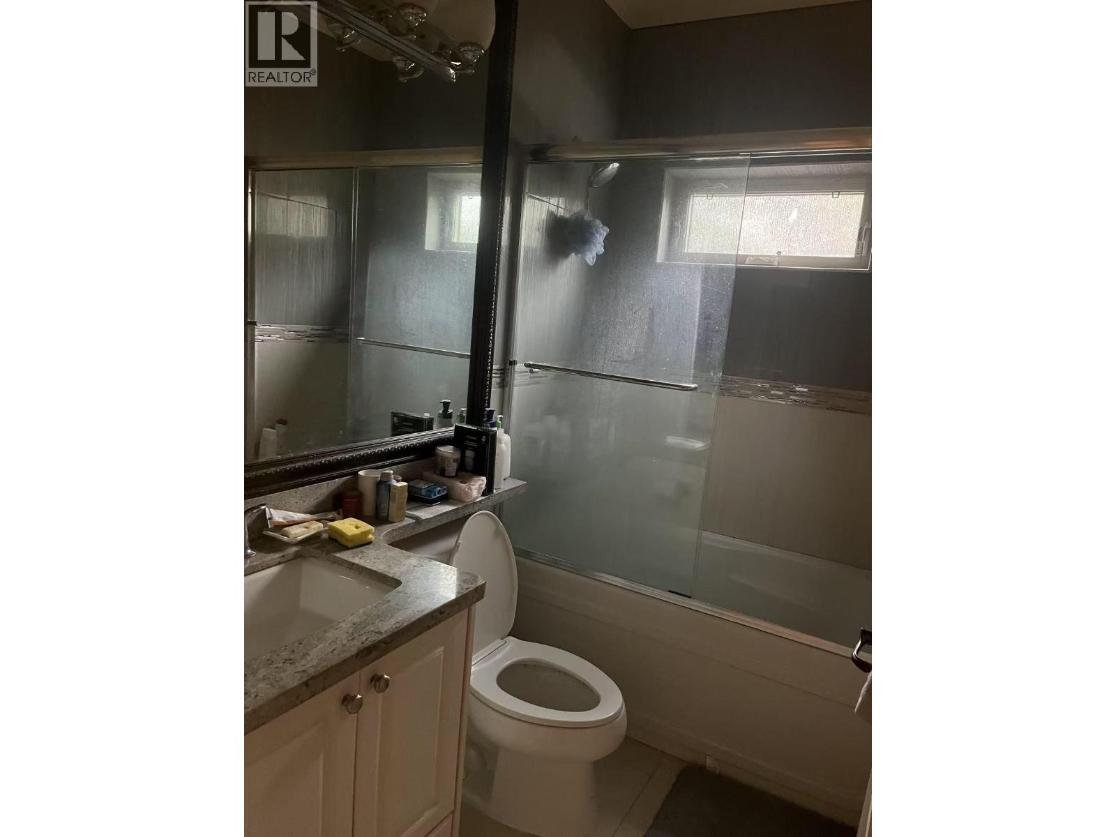 A bathroom with a toilet, sink, and shower.