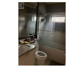 A bathroom with a toilet, sink, and shower.