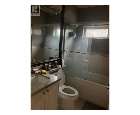 A bathroom with a toilet, sink, and shower.