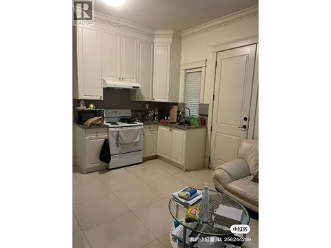 A kitchen with white cabinets and a black stove top oven.