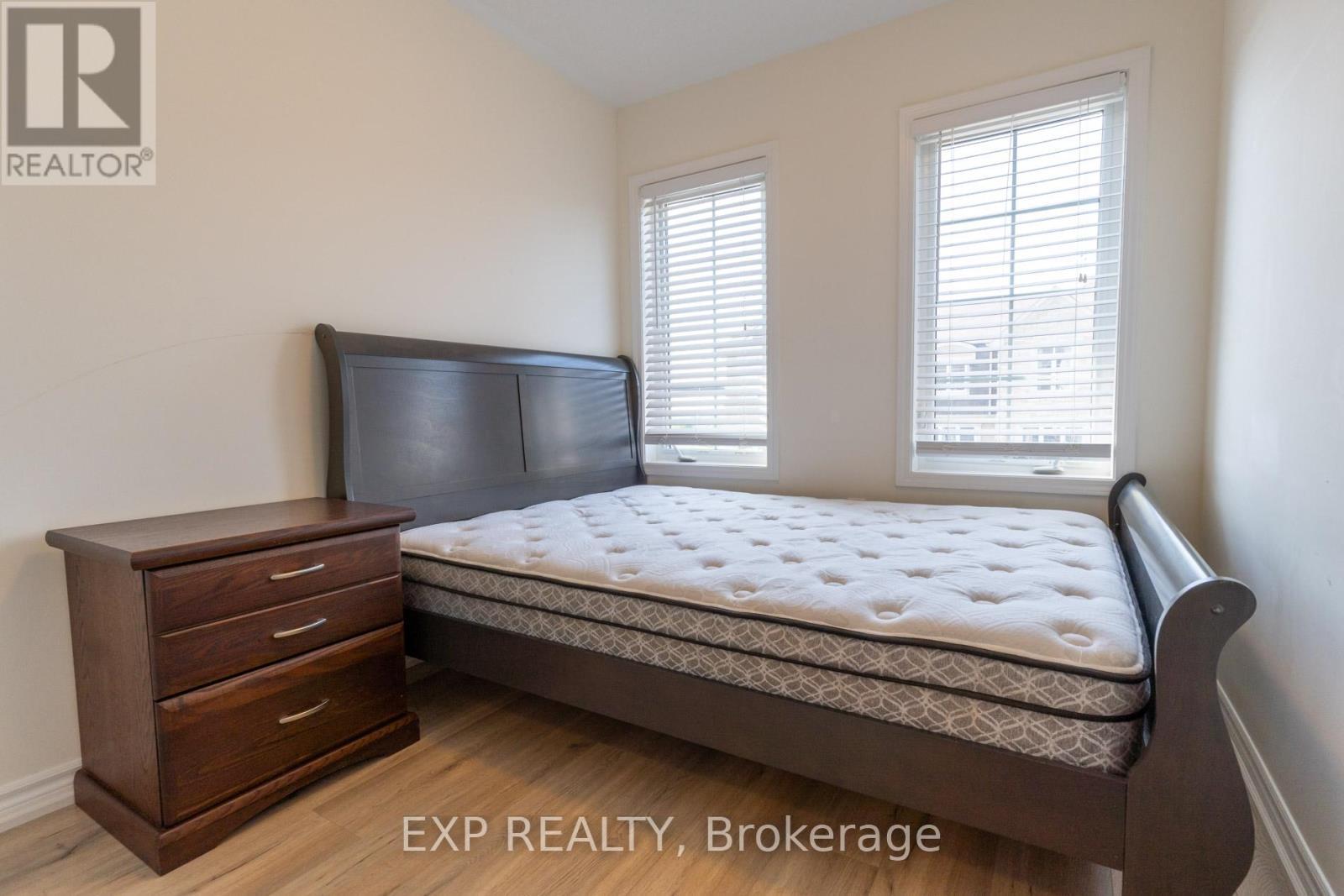 A bedroom with a bed, nightstand, and window.