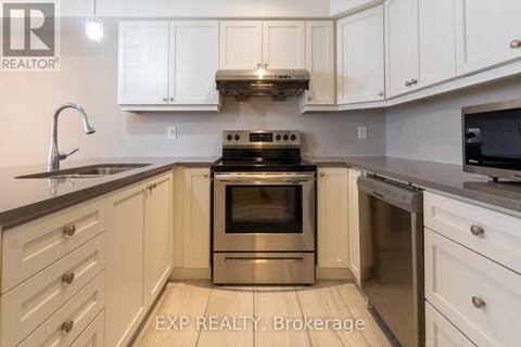 A kitchen with white cabinets and a stove top oven.