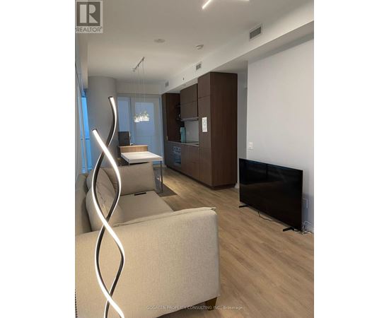 A modern living room with a white couch and a television.