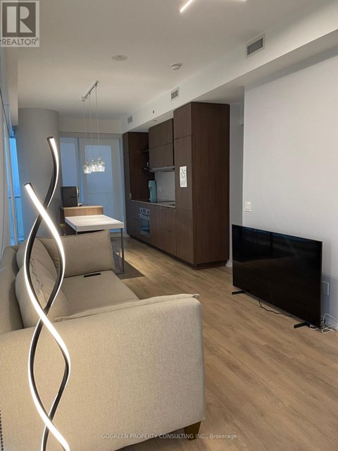 A modern living room with a white couch and a television.
