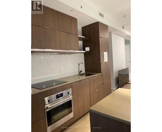 A modern kitchen with wooden cabinets and stainless steel appliances.