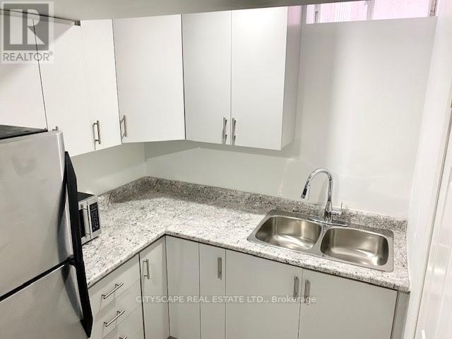 A kitchen with a sink and a refrigerator.