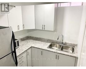 A kitchen with a sink and a refrigerator.