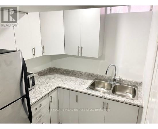 A kitchen with a sink and a refrigerator.