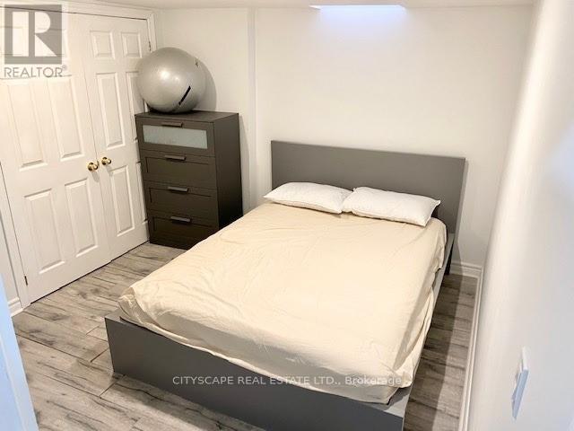 A bedroom with a bed, nightstand, and a door.