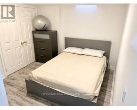A bedroom with a bed, nightstand, and a door.