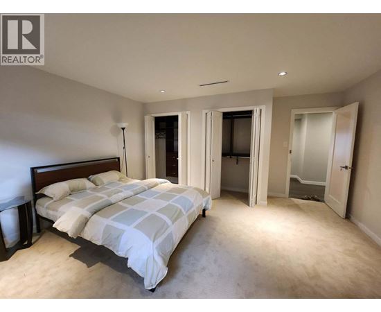 A bedroom with a large bed and a carpeted floor.