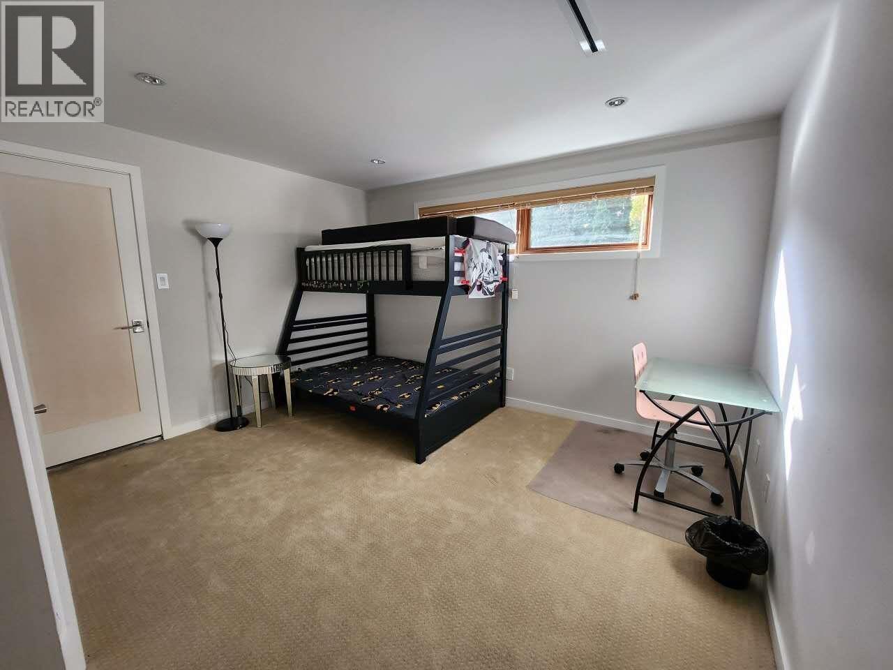 A bedroom with a bunk bed and a desk.