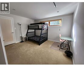 A bedroom with a bunk bed and a desk.
