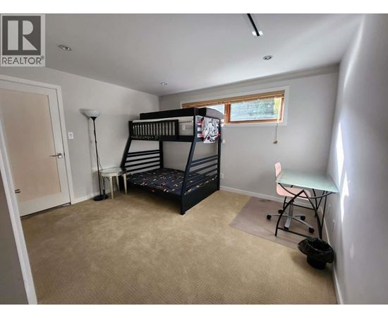 A bedroom with a bunk bed and a desk.