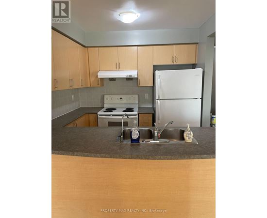 A kitchen with a white fridge, white stove and wooden cabinets.