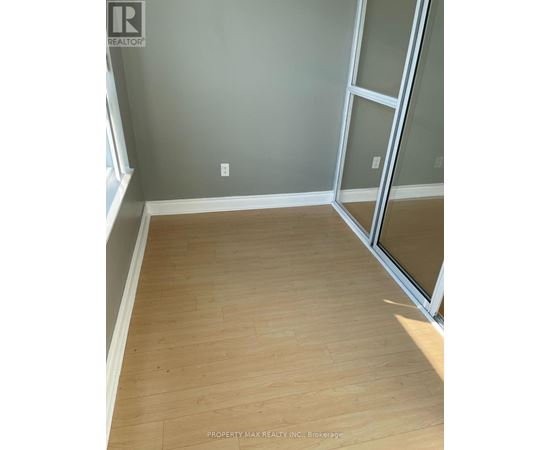 A room with wooden flooring and a glass door.