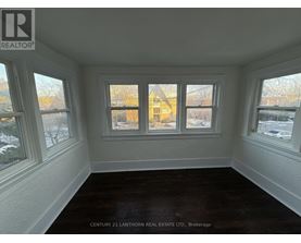 A room with a window showing a view of a building outside.