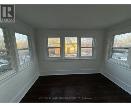 A room with a window showing a view of a building outside.