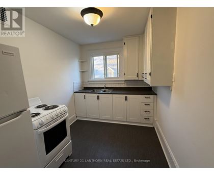 A kitchen with white cabinets and a stove top oven.