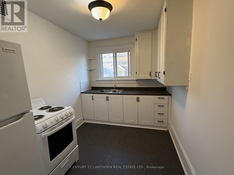 A kitchen with white cabinets and a stove top oven.