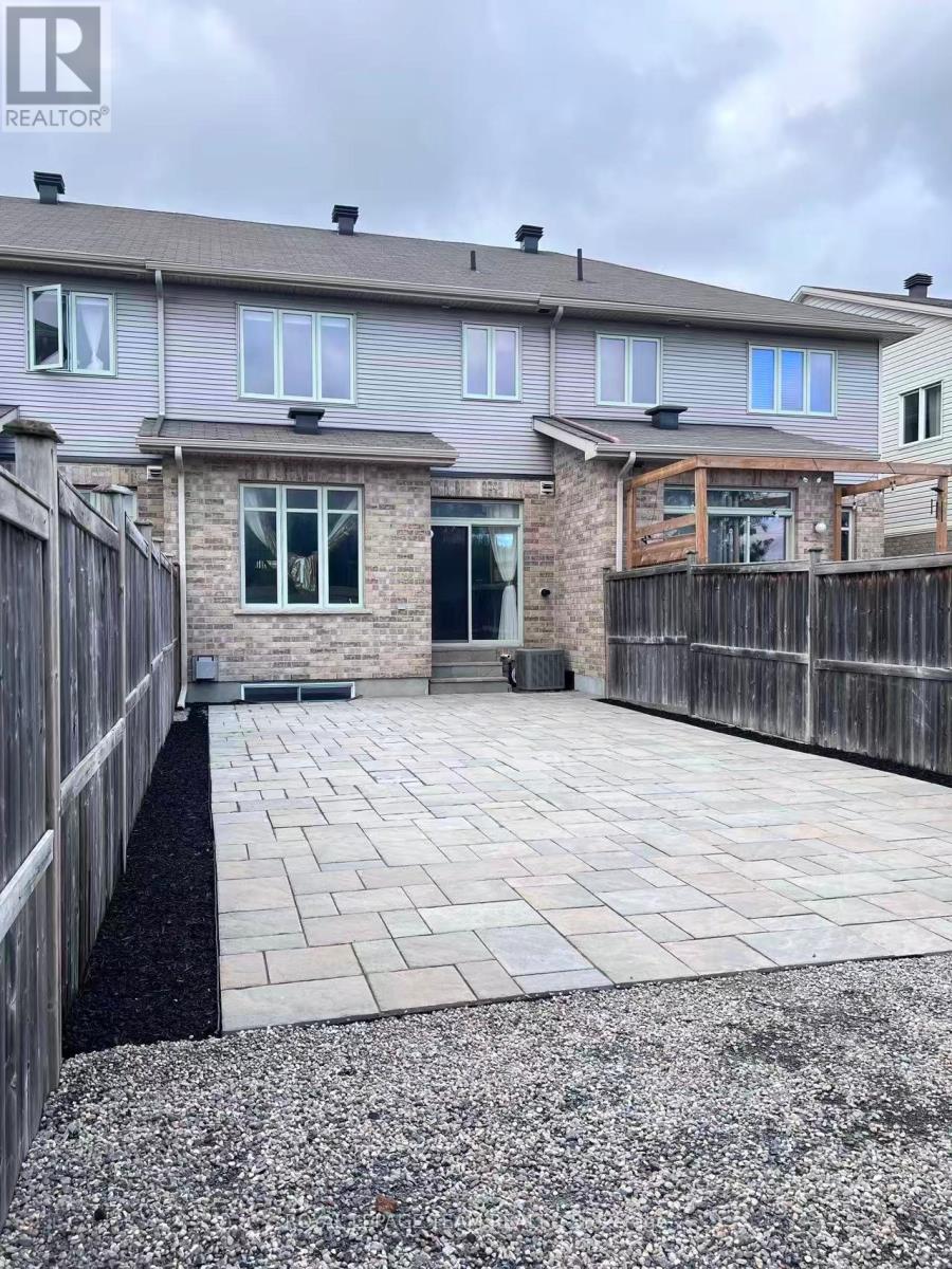 A grey house with a stone pillar in front of it.