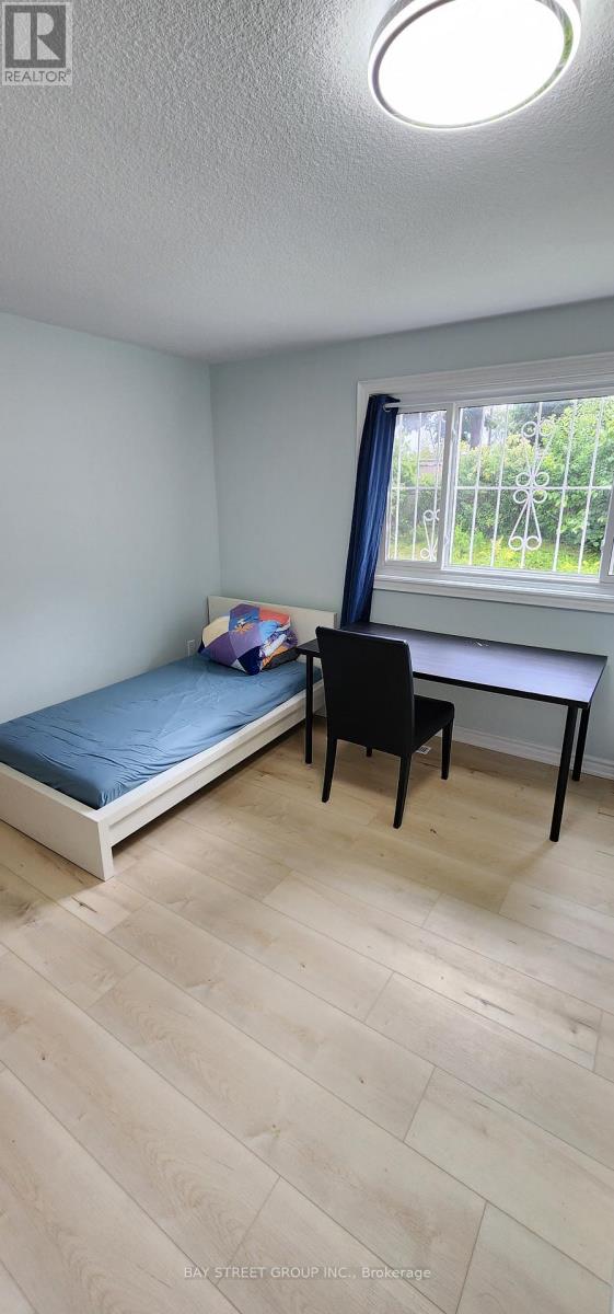A room with a bed, desk, and chair.