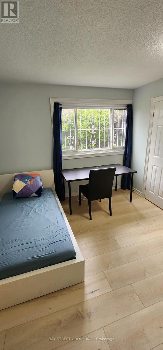 A bedroom with a bed, chair, and window.
