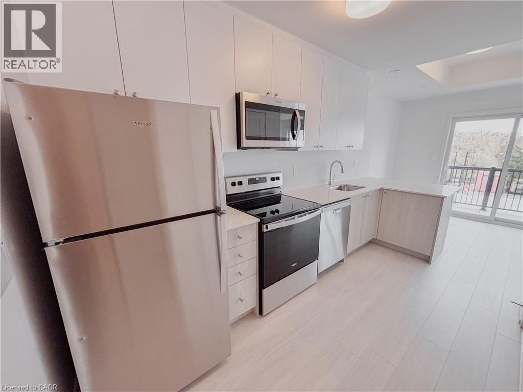 A modern kitchen with white cabinets and stainless steel appliances.