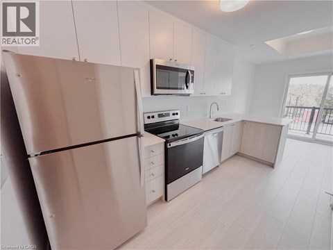 A modern kitchen with white cabinets and stainless steel appliances.