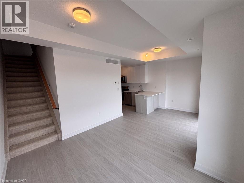 A spacious room with a staircase leading to the upper floor.