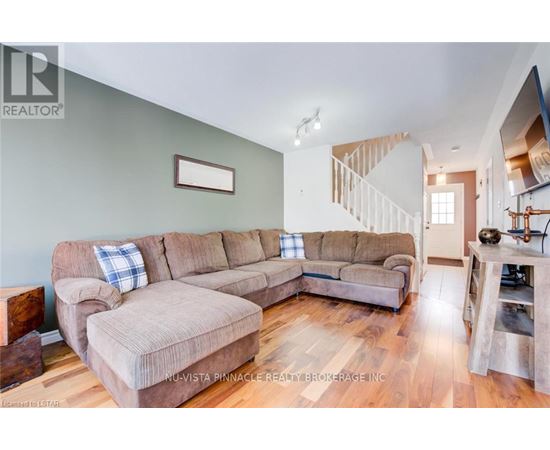 A living room with a large sectional sofa and a smaller loveseat.