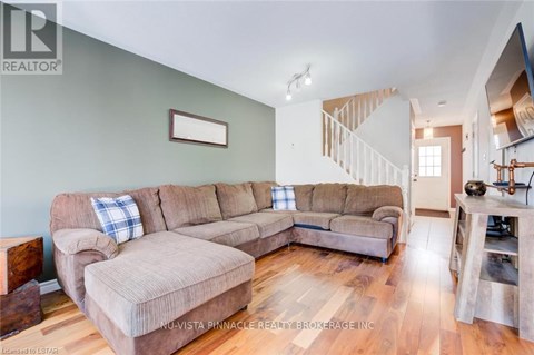 A living room with a large sectional sofa and a smaller loveseat.