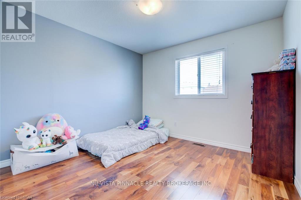 A bedroom with a bed and a bench with stuffed animals on it.