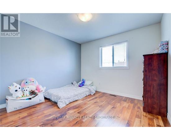 A bedroom with a bed and a bench with stuffed animals on it.