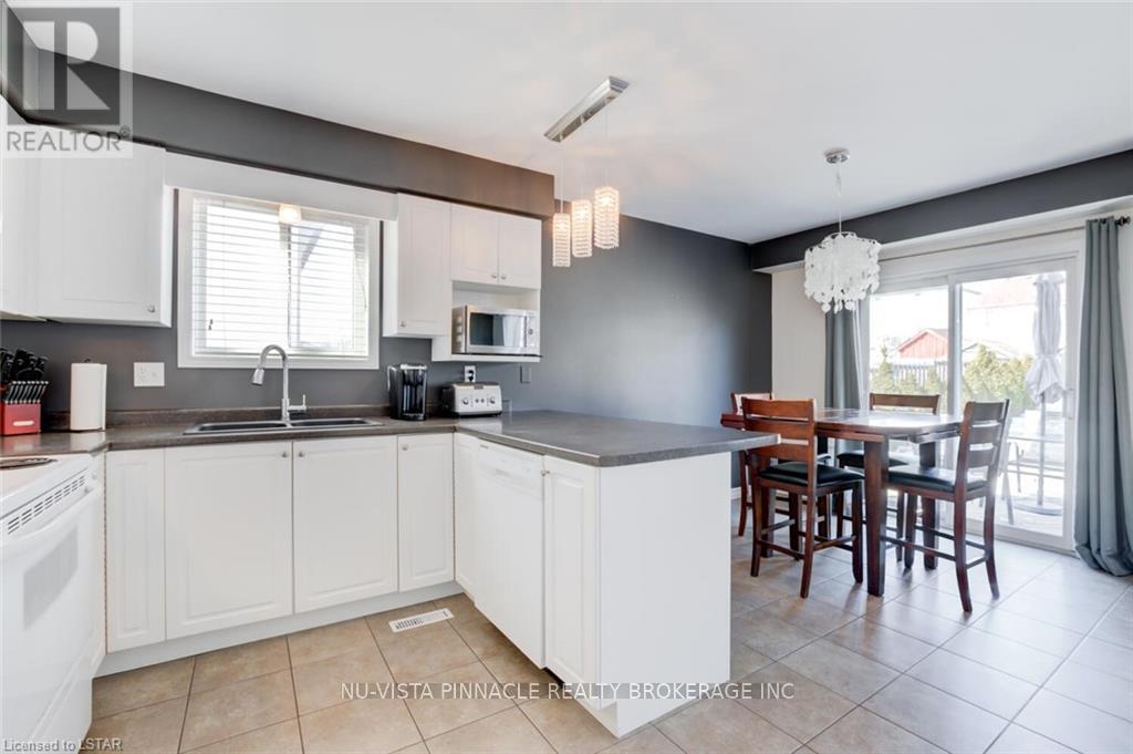 A kitchen with white cabinets and a dining table.