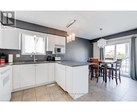 A kitchen with white cabinets and a dining table.