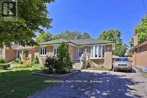 A house with a green lawn and a white car parked in front.