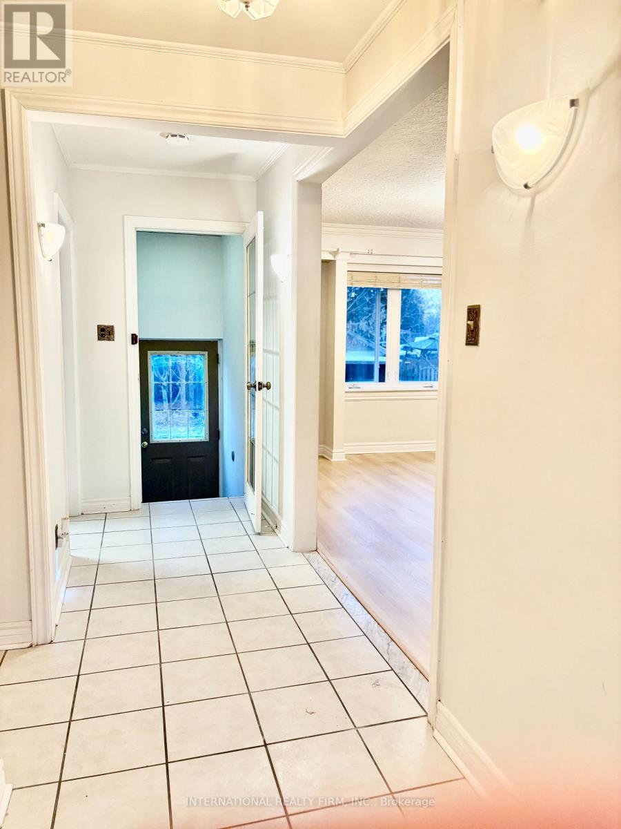A hallway with a black door and white walls.