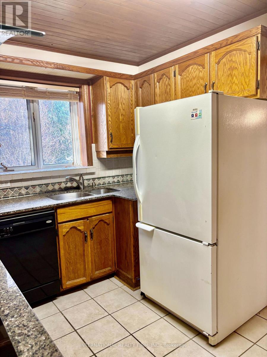 A white refrigerator in a kitchen with wooden cabinets.