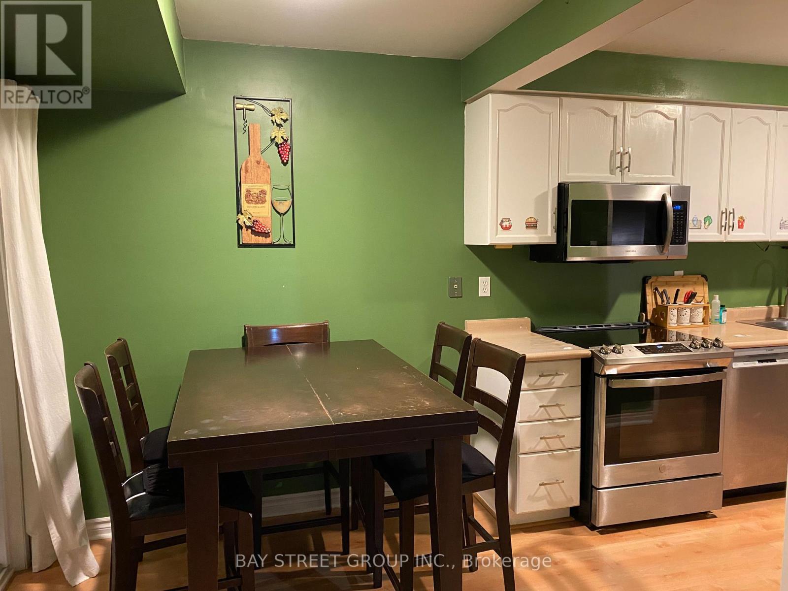 A kitchen with a table and chairs in front of a green wall.