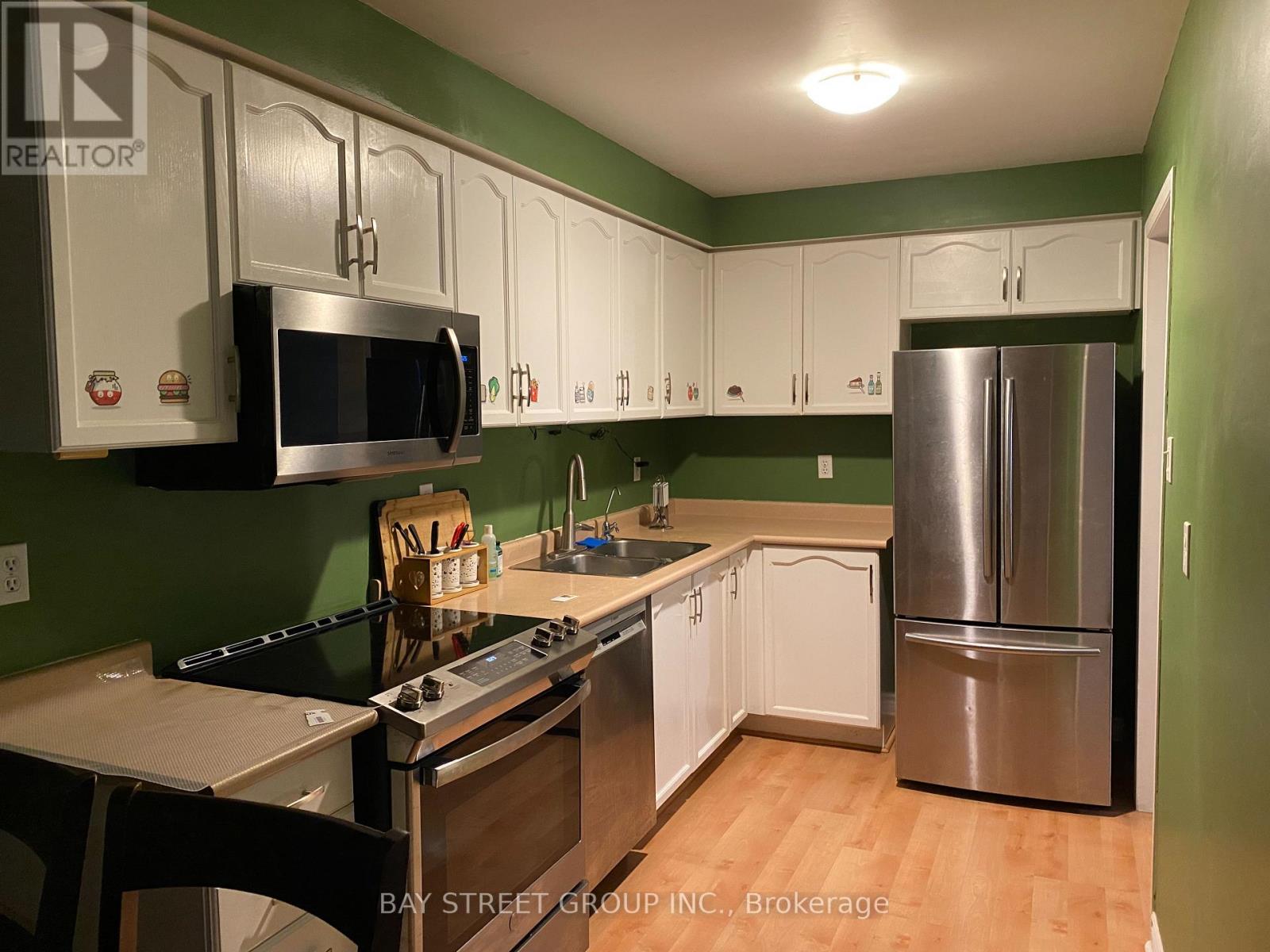 A kitchen with green walls and white cabinets.