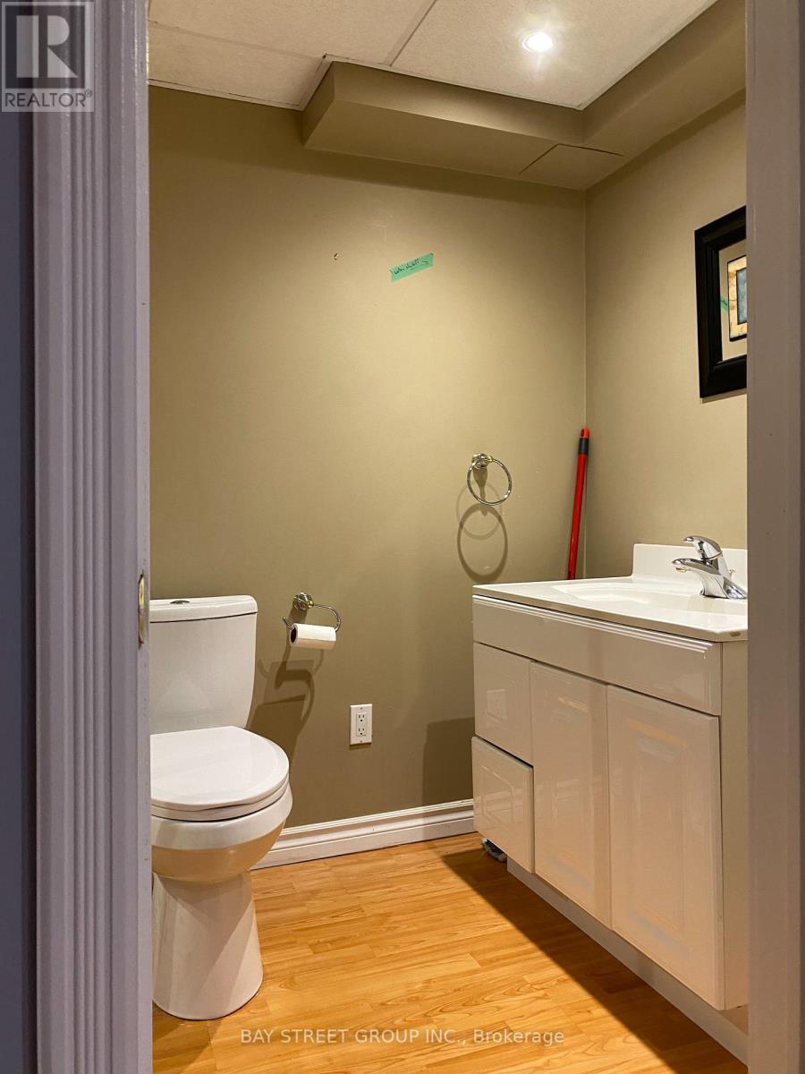 A white toilet sits next to a sink in a small bathroom.
